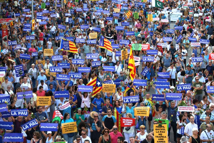 People hold placards and flag as they take part in a march of unity after last week attacks, in Barcelona